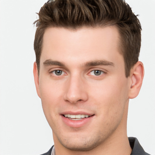 Joyful white young-adult male with short  brown hair and grey eyes