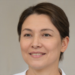 Joyful white adult female with medium  brown hair and brown eyes