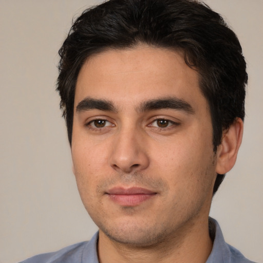 Joyful white young-adult male with short  black hair and brown eyes