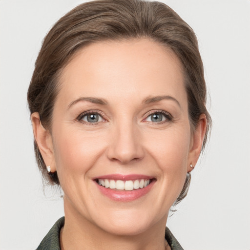 Joyful white adult female with medium  brown hair and grey eyes