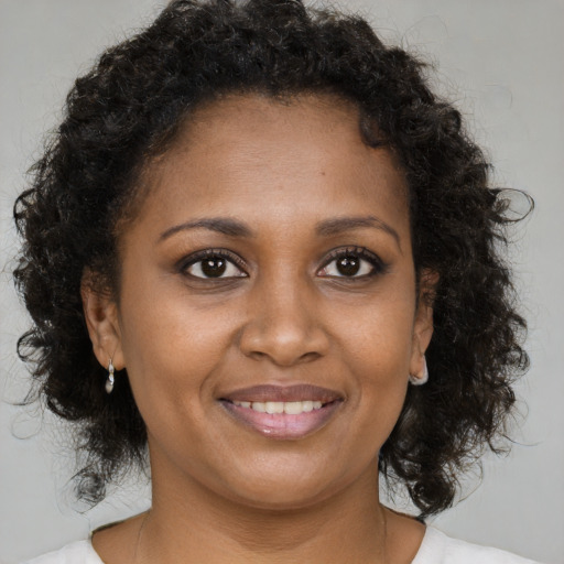 Joyful black young-adult female with medium  brown hair and brown eyes