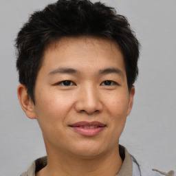 Joyful asian young-adult male with short  brown hair and brown eyes