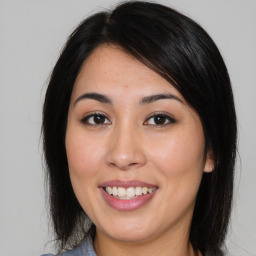 Joyful asian young-adult female with medium  brown hair and brown eyes