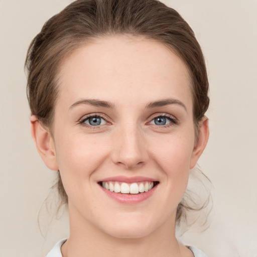 Joyful white young-adult female with medium  brown hair and grey eyes