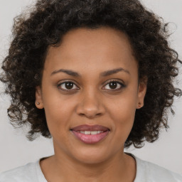 Joyful black young-adult female with medium  brown hair and brown eyes