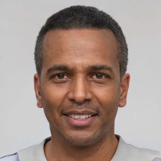 Joyful latino adult male with short  black hair and brown eyes