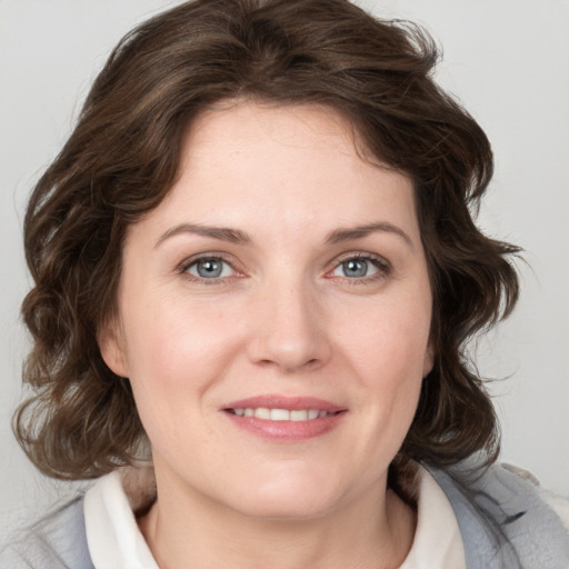 Joyful white young-adult female with medium  brown hair and blue eyes