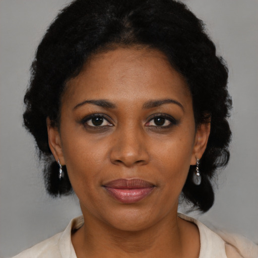 Joyful black adult female with short  black hair and brown eyes