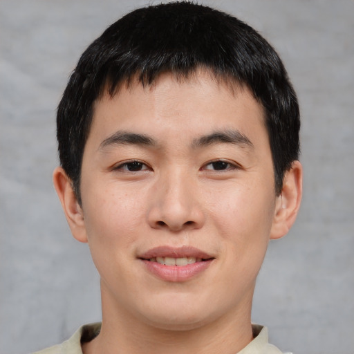 Joyful asian young-adult male with short  brown hair and brown eyes
