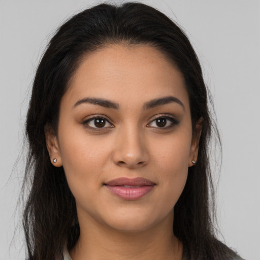 Joyful latino young-adult female with long  brown hair and brown eyes