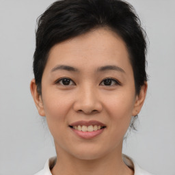 Joyful asian young-adult female with short  brown hair and brown eyes