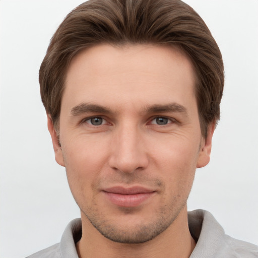 Joyful white young-adult male with short  brown hair and grey eyes