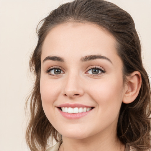 Joyful white young-adult female with long  brown hair and green eyes