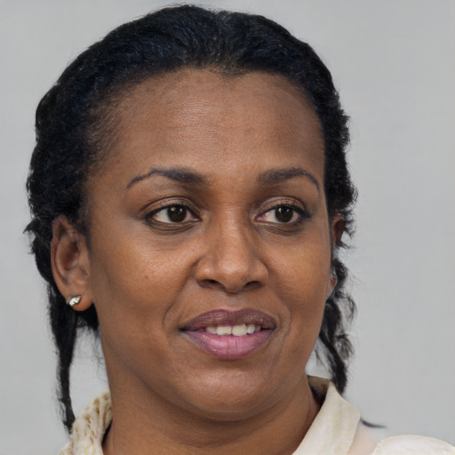 Joyful black adult female with medium  brown hair and brown eyes
