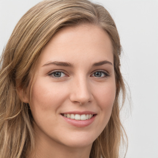 Joyful white young-adult female with long  brown hair and grey eyes