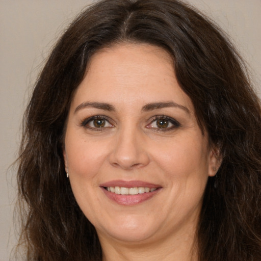 Joyful white adult female with long  brown hair and brown eyes