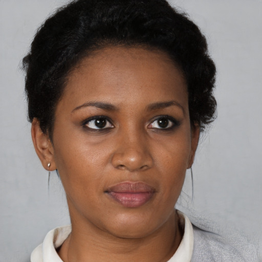 Joyful black young-adult female with short  brown hair and brown eyes