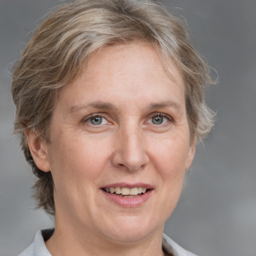 Joyful white adult female with medium  brown hair and grey eyes