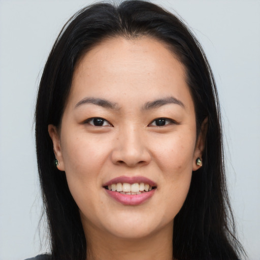 Joyful asian young-adult female with long  brown hair and brown eyes