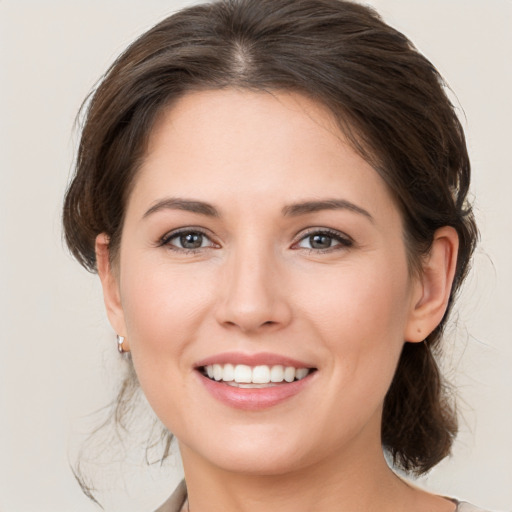 Joyful white young-adult female with medium  brown hair and grey eyes