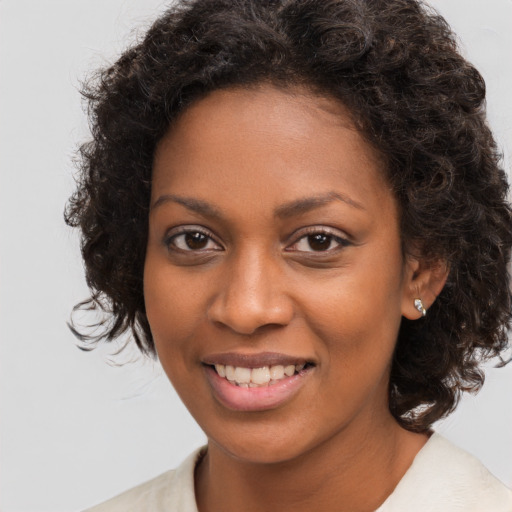 Joyful black young-adult female with medium  brown hair and brown eyes