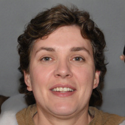 Joyful white adult female with medium  brown hair and blue eyes