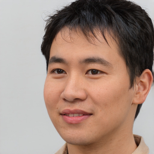 Joyful asian young-adult male with short  brown hair and brown eyes