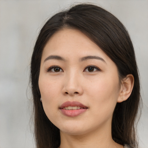 Joyful asian young-adult female with long  brown hair and brown eyes