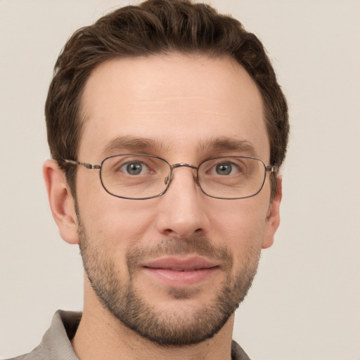 Joyful white young-adult male with short  brown hair and grey eyes