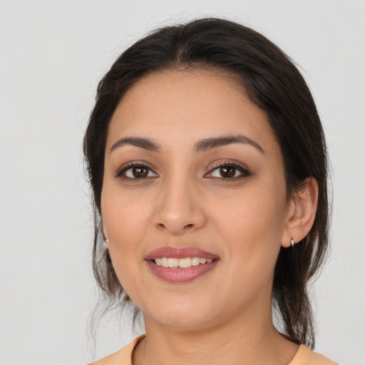 Joyful latino young-adult female with medium  brown hair and brown eyes