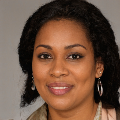 Joyful black young-adult female with long  brown hair and brown eyes