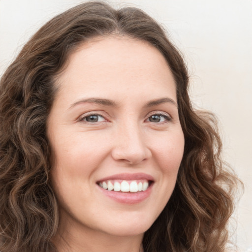 Joyful white young-adult female with long  brown hair and green eyes