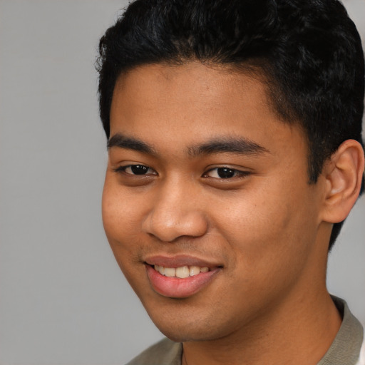 Joyful latino young-adult male with short  black hair and brown eyes