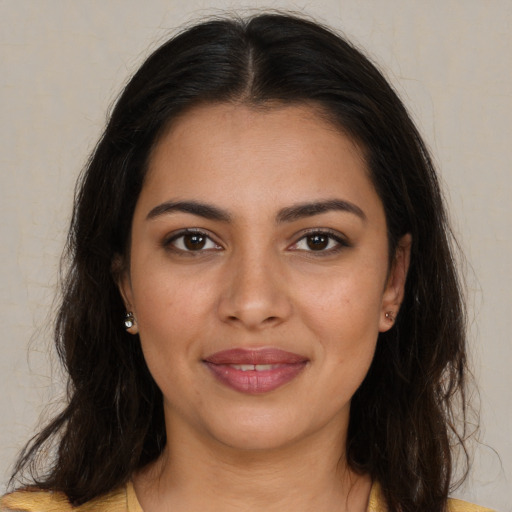 Joyful latino young-adult female with long  brown hair and brown eyes