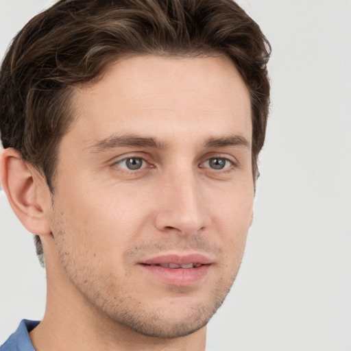 Joyful white young-adult male with short  brown hair and grey eyes