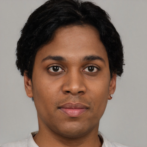 Joyful black young-adult male with short  black hair and brown eyes