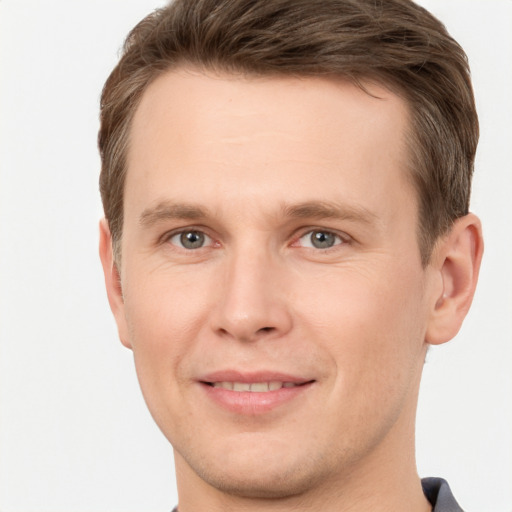 Joyful white young-adult male with short  brown hair and grey eyes