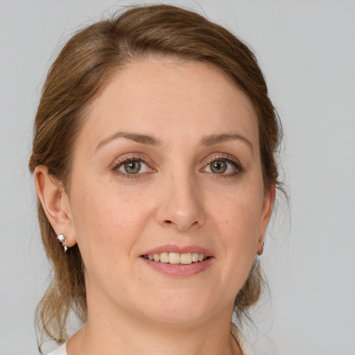 Joyful white young-adult female with medium  brown hair and green eyes