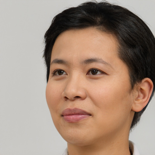Joyful asian young-adult female with short  brown hair and brown eyes
