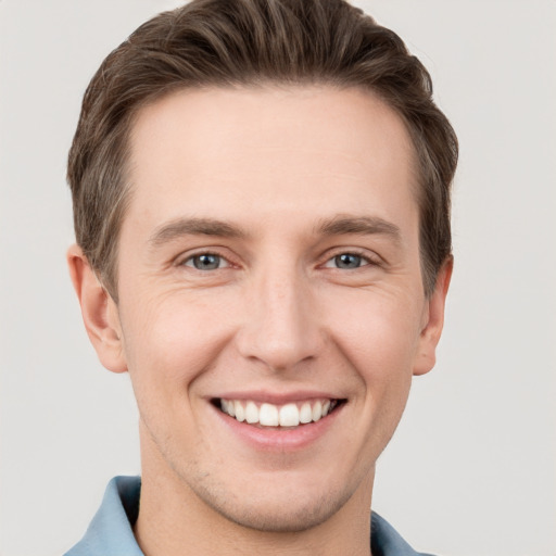 Joyful white young-adult male with short  brown hair and grey eyes