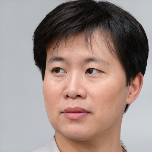 Joyful asian adult male with short  brown hair and brown eyes