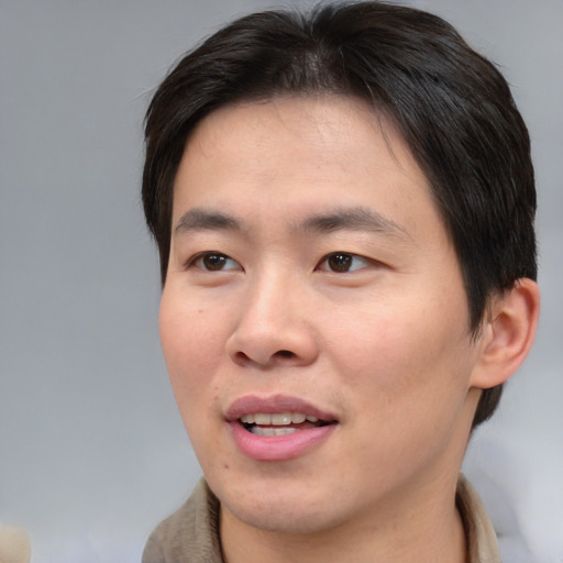 Joyful asian young-adult male with short  brown hair and brown eyes