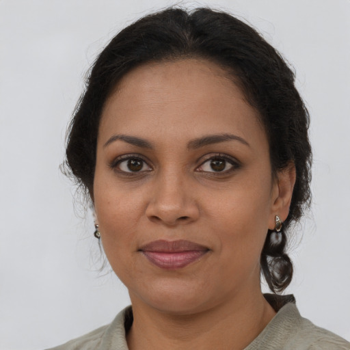 Joyful latino adult female with medium  brown hair and brown eyes