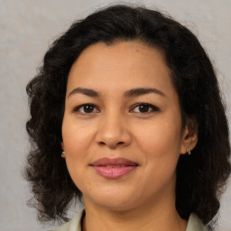 Joyful latino young-adult female with medium  brown hair and brown eyes