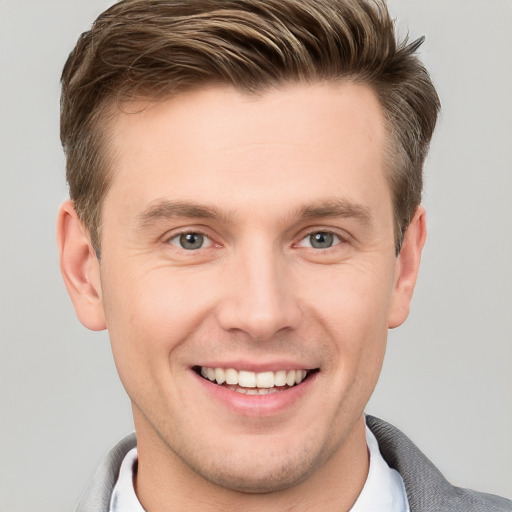 Joyful white young-adult male with short  brown hair and grey eyes