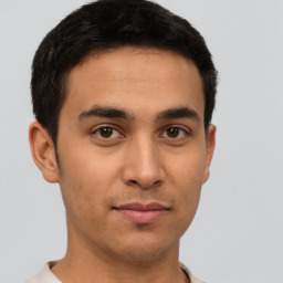 Joyful latino young-adult male with short  brown hair and brown eyes