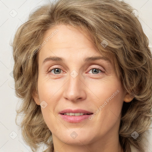 Joyful white adult female with medium  brown hair and green eyes