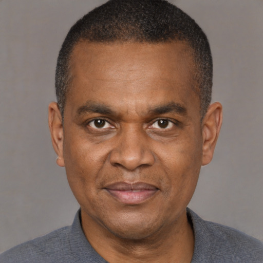 Joyful black adult male with short  brown hair and brown eyes