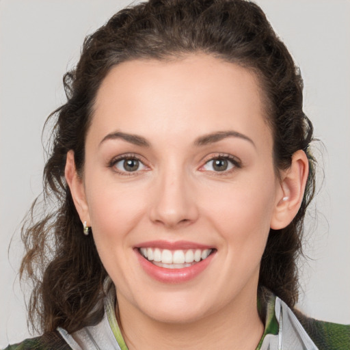 Joyful white young-adult female with medium  brown hair and green eyes