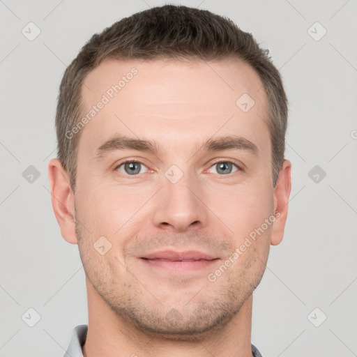 Joyful white young-adult male with short  brown hair and grey eyes